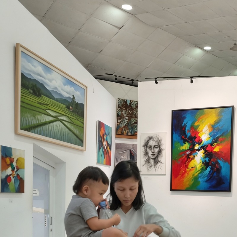 Seorang ibu membawa anak yang mengikuti workshop melukis